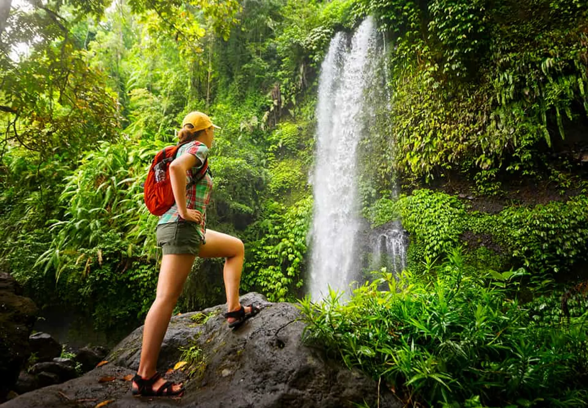 Young-woman-backpacker-looking-at-the-waterfall-in-jungles